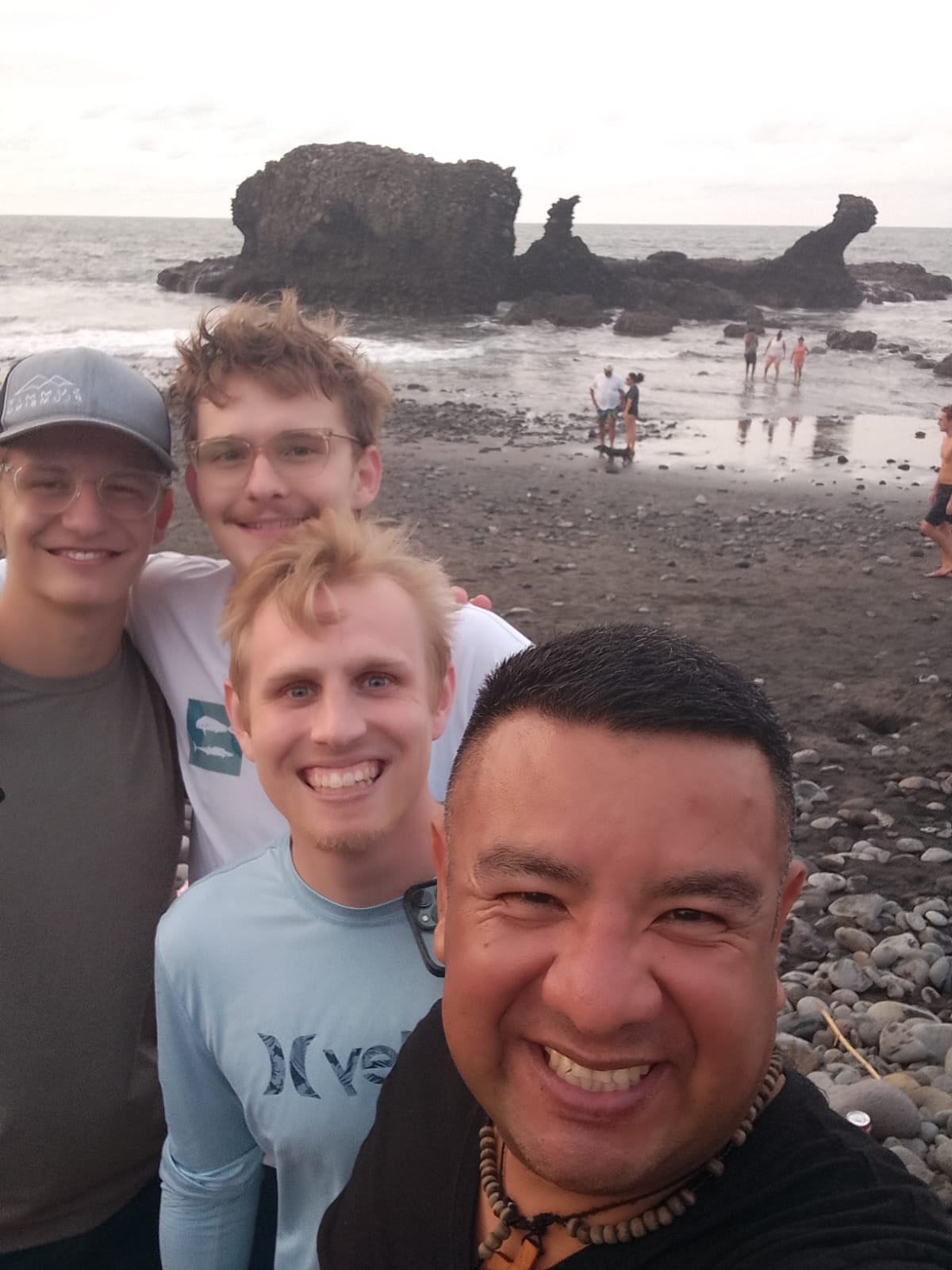 Group of friends smiling together at El Tunco beach at sunset