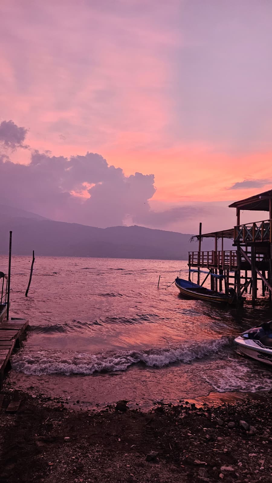 Coatepeque lake at pink sunset with boats