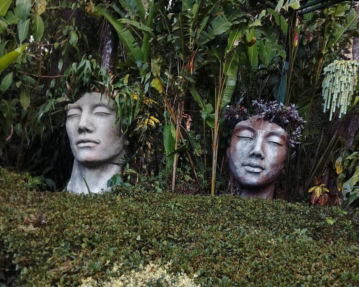Sculpted stone faces set in a lush tropical garden — luxury private tours in El Salvador